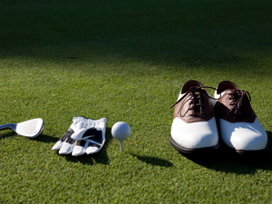 pair of shoes and golf materials on green